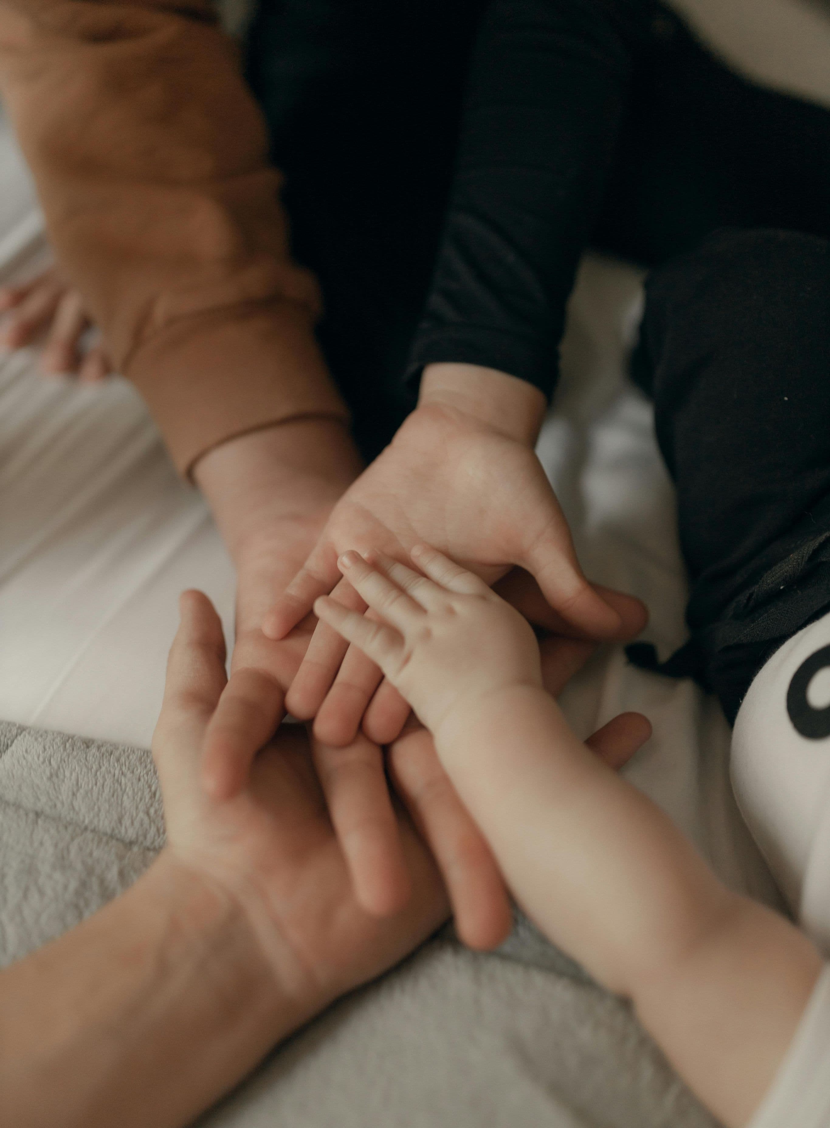 Famille réunie, proches et patient, mains posées les unes sur les autres